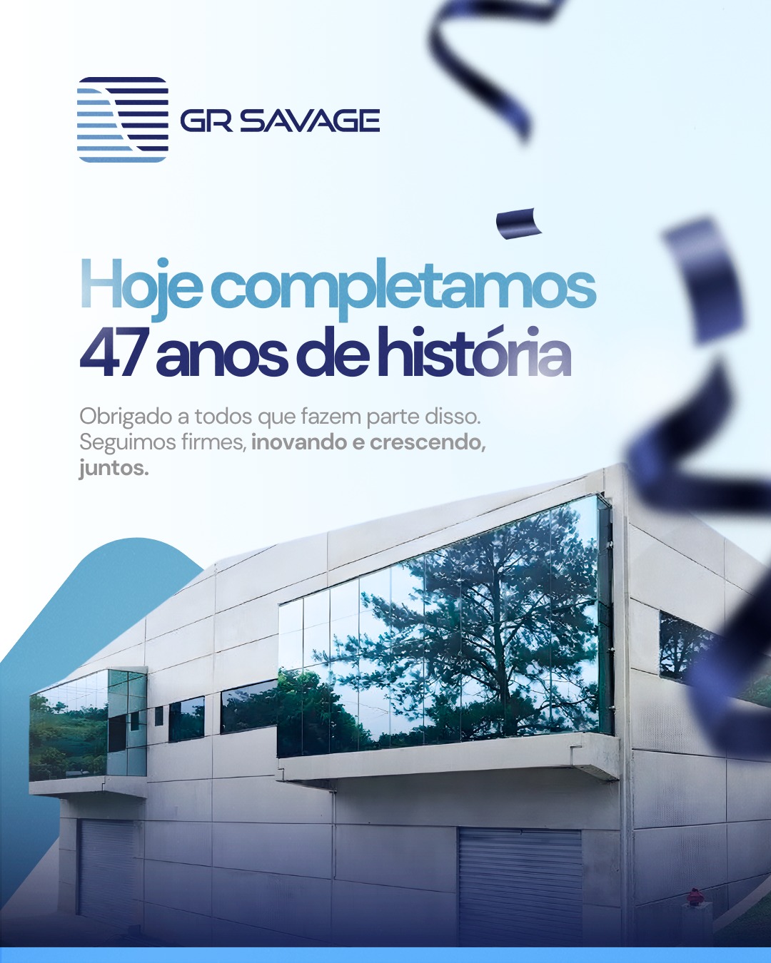 Arte institucional comemorativa da GR Savage. Na parte superior, o logotipo da marca e o texto "Hoje completamos 47 anos de história". Abaixo, uma fotografia da fachada moderna da sede da empresa, um edifício industrial cinza com grandes janelas de vidro espelhado que refletem a vegetação ao redor. Elementos decorativos de confetes azuis escuros flutuam pela imagem.